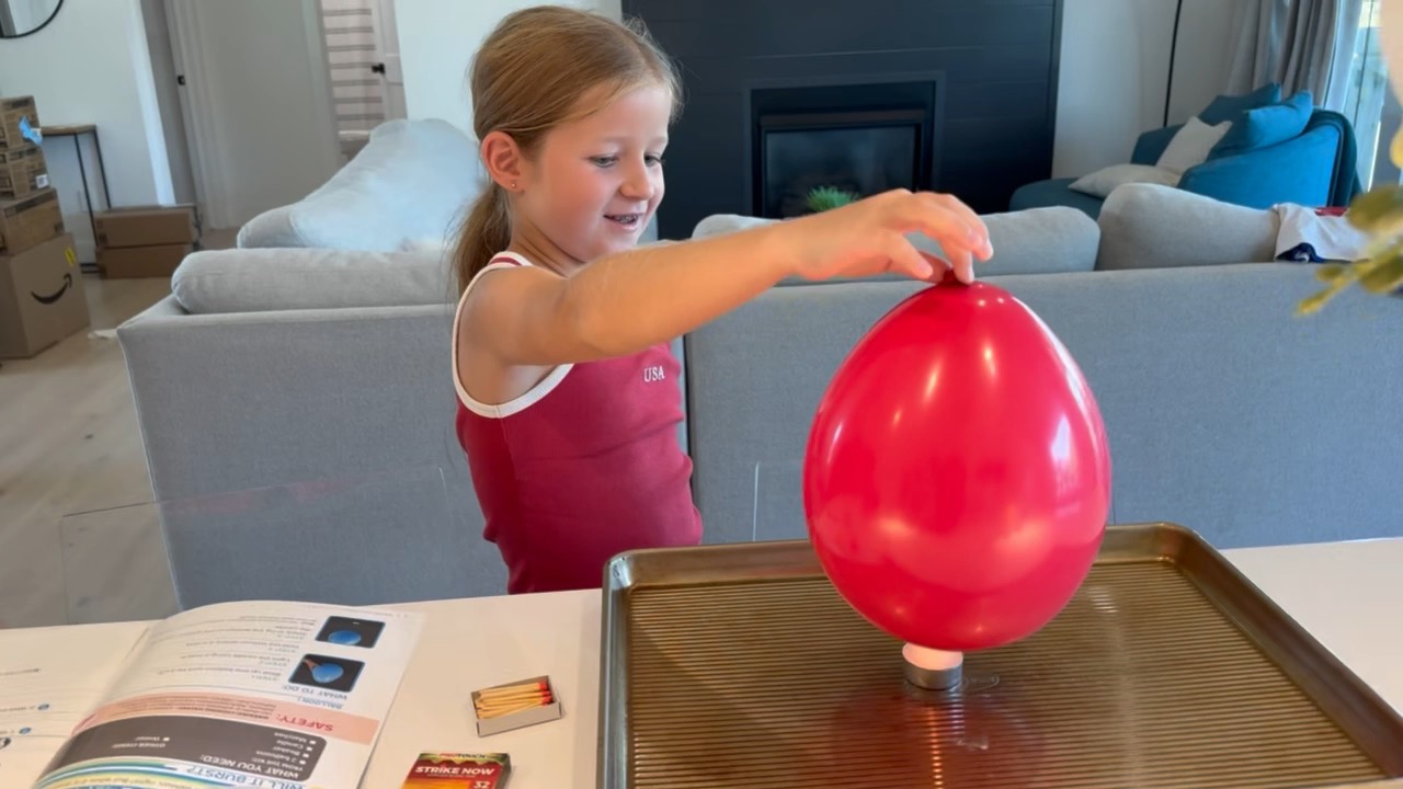 Pressing a red balloon onto a tea light
