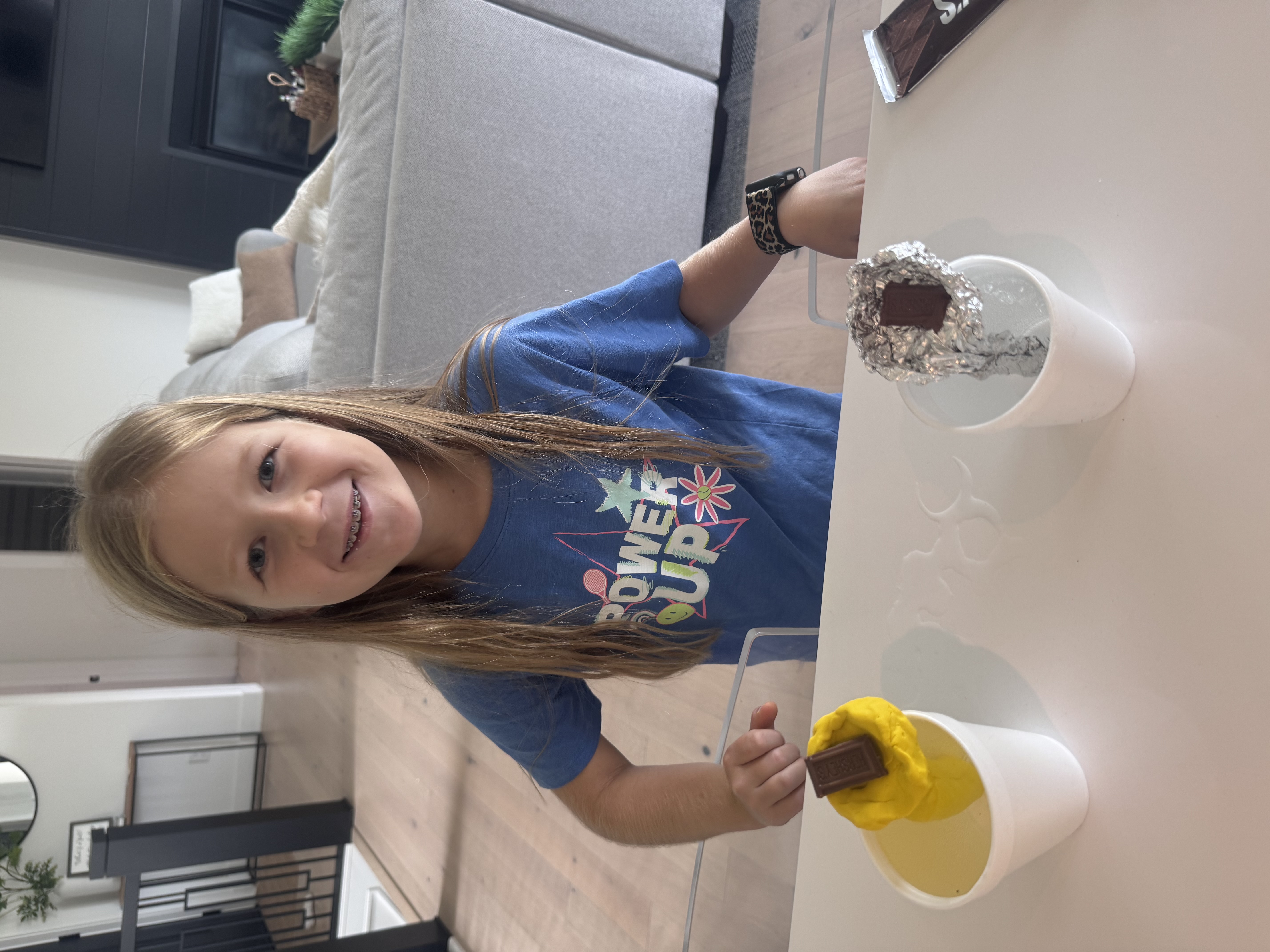 Two foam cups with clay and foil holders and pieces of chocolate