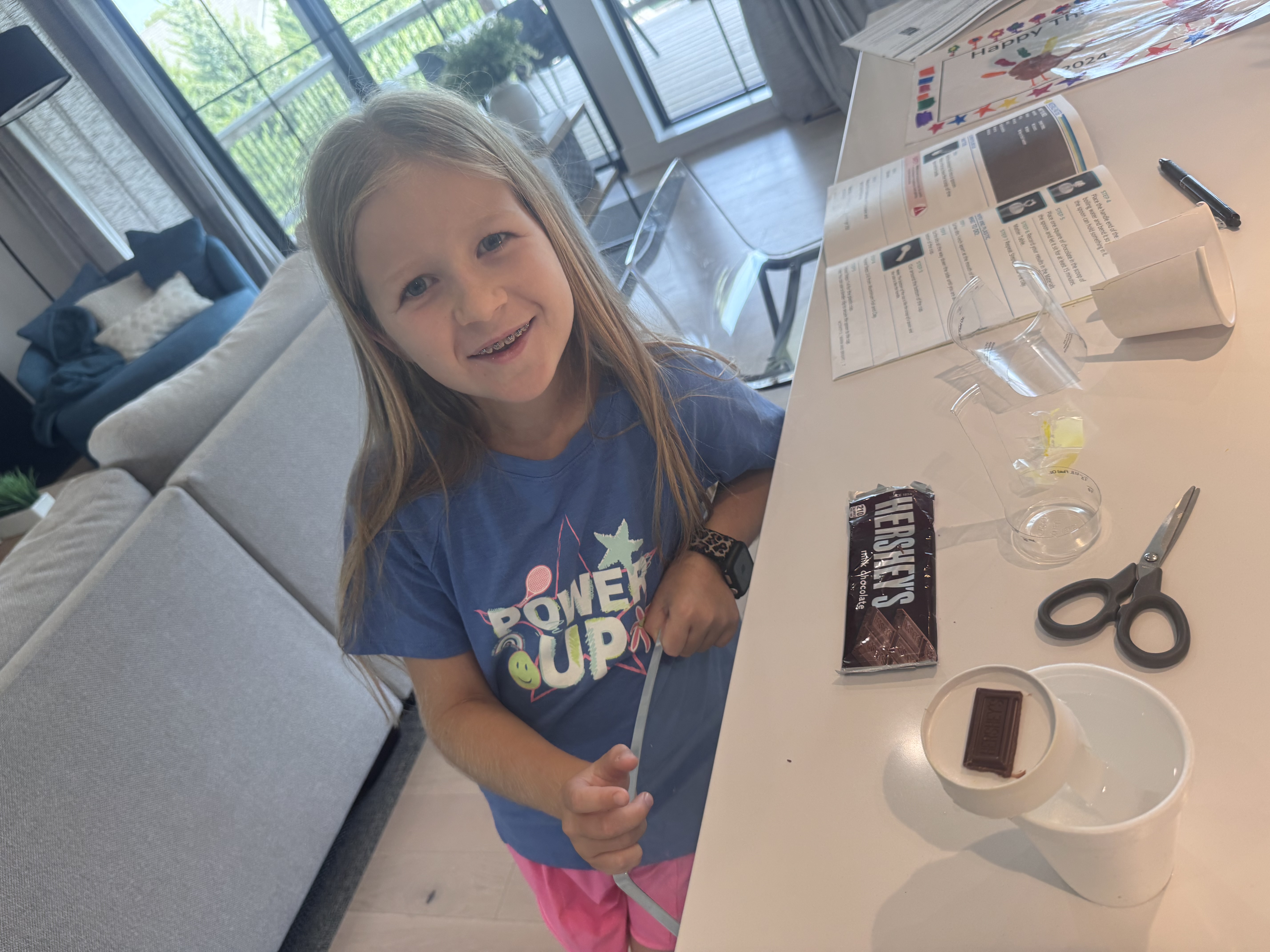 A piece of chocolate on a cup next to the activity sheet